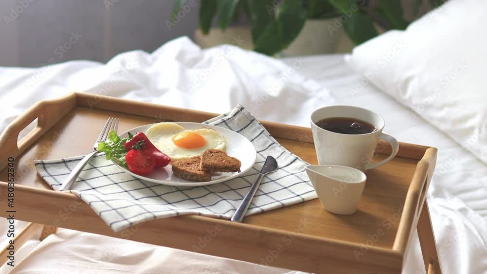 Breakfast on a tray in bed. Morning. Fried eggs in the shape of a heart with vegetables. Breakfast on a tray in bed. Morning. Fried eggs in the shape of a heart with vegetables.