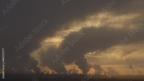 Factory chimneys pollute the air, environmental problems. It's snowing ash at sunset. Industrial pollution, exhaust fumes from the chimney. Industrial area, thick smoke. Climate change, ecology, atmos