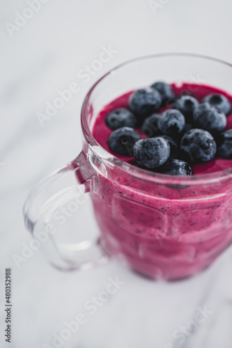raspberry and dragonfruit smoothie with blueberries topping in pint glass