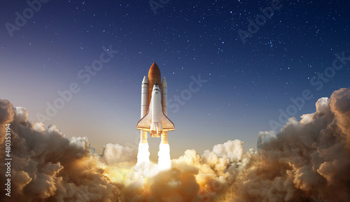 Spaceship takes off into the night sky on a mission. Rocket starts into space concept.Elements of this image furnished by NASA