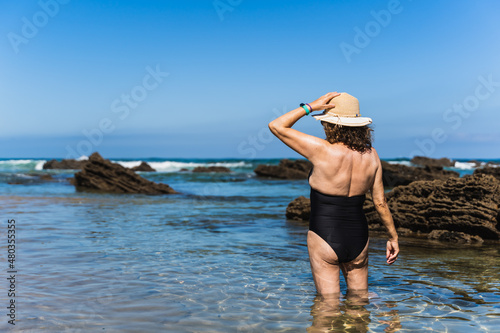 Obraz na płótnie old woman on vacation on the beach. w salonie