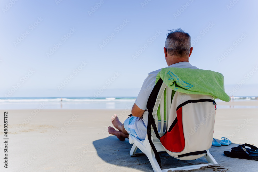 old man sitting on the beach