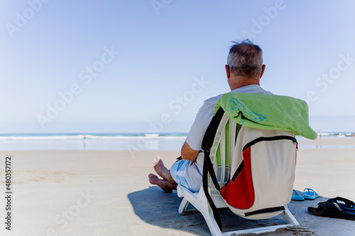 Obraz na płótnie old man sitting on the beach w salonie