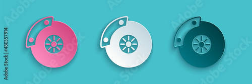 Paper cut Car brake disk with caliper icon isolated on blue background. Paper art style. Vector
