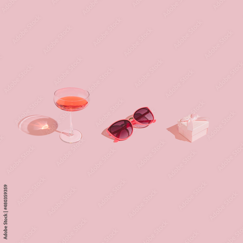 Cute and romantic self care kit made of wine glass, gift box and pink glasses on pastel background. Trendy, minimal Valentine's Day aesthetic. Cute and romantic self care kit made of wine glass, gift box and pink glasses on pastel background. Trendy, minimal Valentine's Day aesthetic.