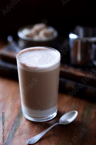 Coffee with milk on wooden background. Soft focus. Close up.