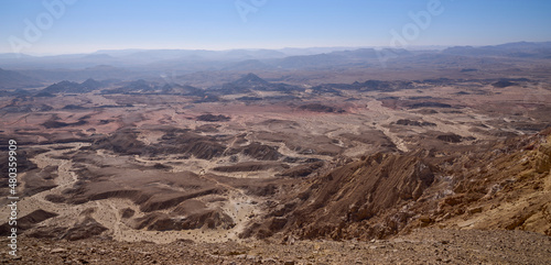 Panoramic view on Crater Ramon from Mount Ardon, the Negev desert. Makhtesh Ramon - erosion crater, the most picturesque natural landmark of Israel. Orange, red and black colors of the desert.