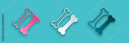 Paper cut Dog bone icon isolated on blue background. Pets food symbol. Paper art style. Vector