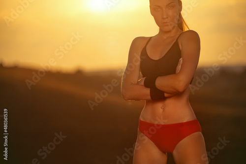 Gym and fitness concept. Muscular young sports woman doing workout outdoors.