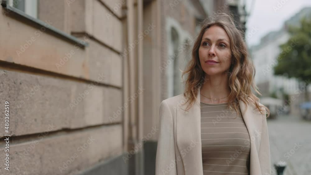 Business woman with calm face walking on city street Business woman with calm face walking on city street