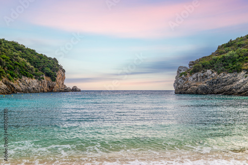 Calm beach of Mediterranean sea near high hill with forest © YouraPechkin