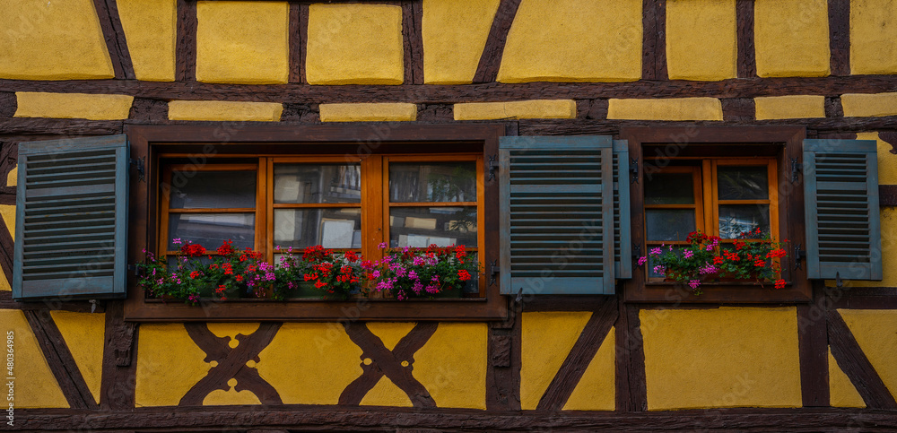 Old house wall with windowsr. Front view of traditional half timbered houses with antique wooden shutters.