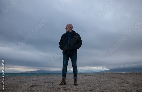 Adult man in winter clothes on beach during sunset. Almeria, Spain