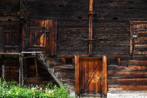 Weathered old wood texture background. Facade wooden house in village in Swiss Alps. The barns, stores, stables and old houses. Timber wood wall texture background.
