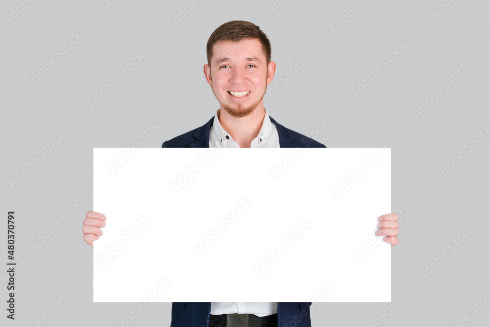 A businessman holds a rectangular white blank board with a place for text in his hands A businessman holds a rectangular white blank board with a place for text in his hands