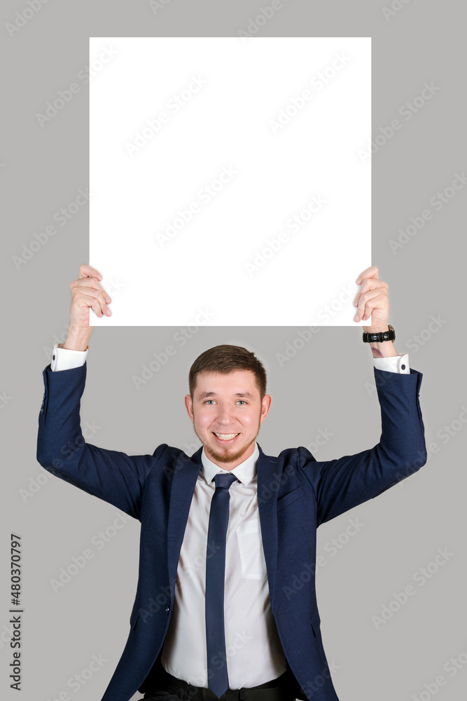 A businessman in formal attire holds a square white poster, mockup A businessman in formal attire holds a square white poster, mockup