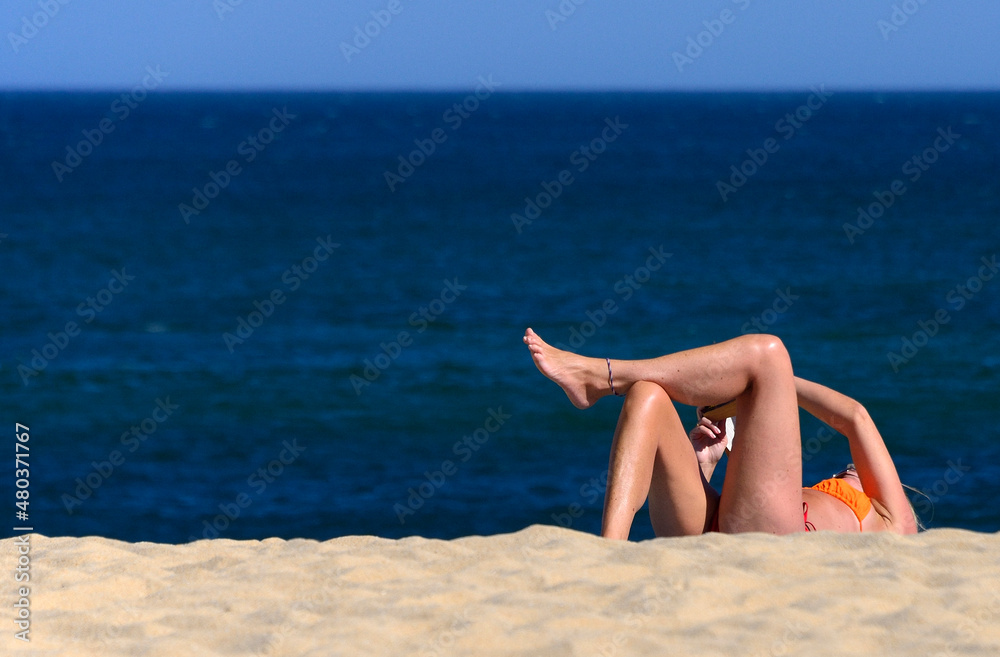 Single woman reading on the beach, Batata beach, Atlantic Ocean, Lagos, city center, Faro district, Algarve, Portugal, Europe