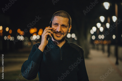 A man talking on his phone outside at night