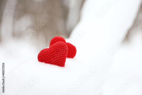 Love hearts  Valentine s card  two red knitted symbols of passion in the snow forest. Background for romantic event  celebration or winter weather
