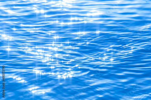 Sun light reflecting or sparkling glitter on water of sea or ocean with beautiful sky blue light tone.