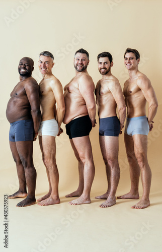 group of multiethnic men posing for a male edition body positive beauty set. Shirtless guys with different age  and body wearing boxers underwear