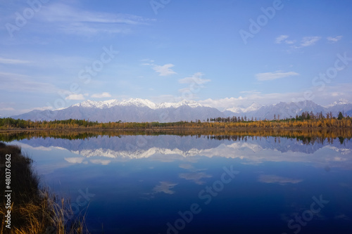 Mountain lake in the taiga and Kodar ridge