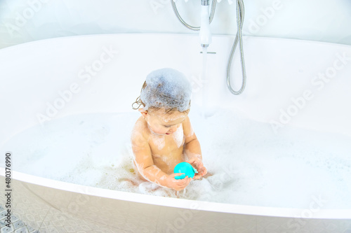 A child bathes in a bubble bath. Selective focus.