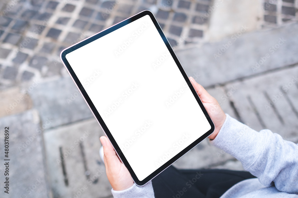 Top view mockup image of a woman holding digital tablet with blank white desktop screen