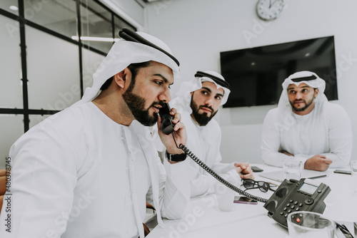 Group of business managers from the emirates meeting and working together in Dubai. Arabian businessmen wearing traditional clothes