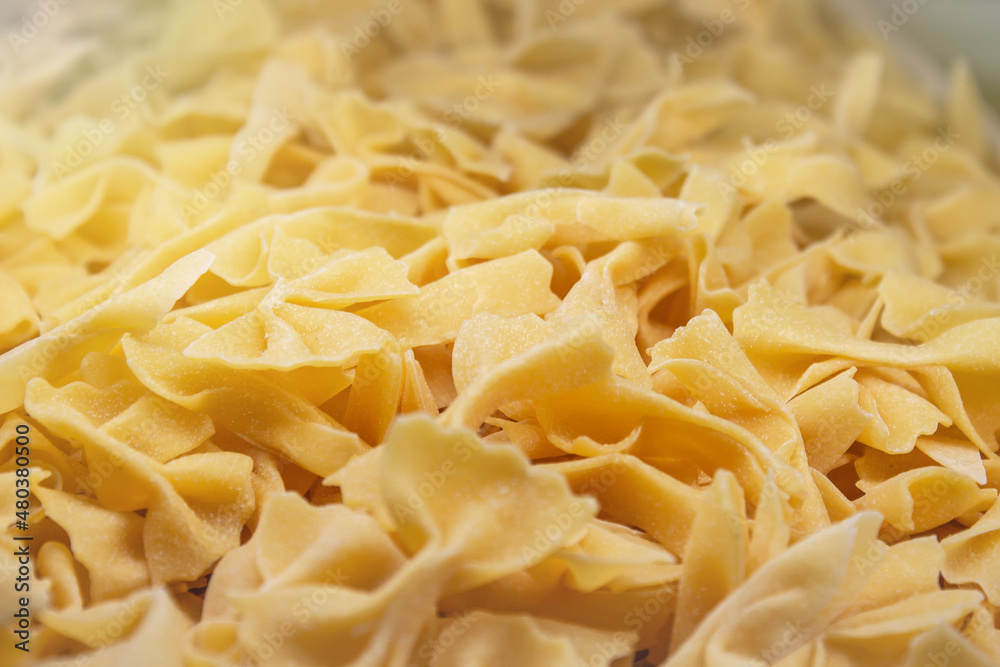 freshly made dry uncooked farfalle pasta as a background