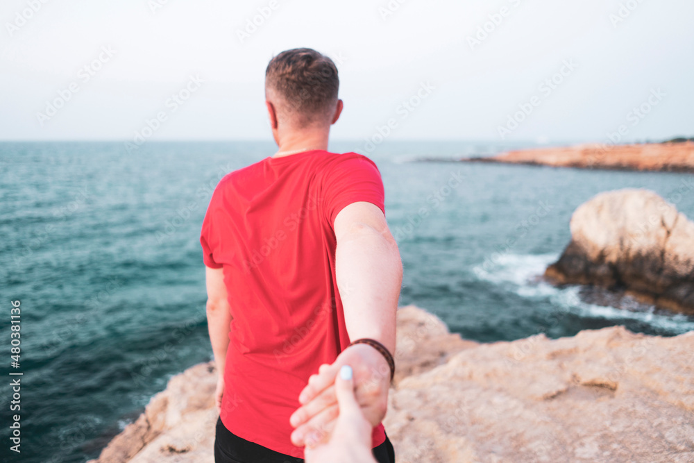 a heterosexual travel couple, peson holding hand and pulling to the destinaton