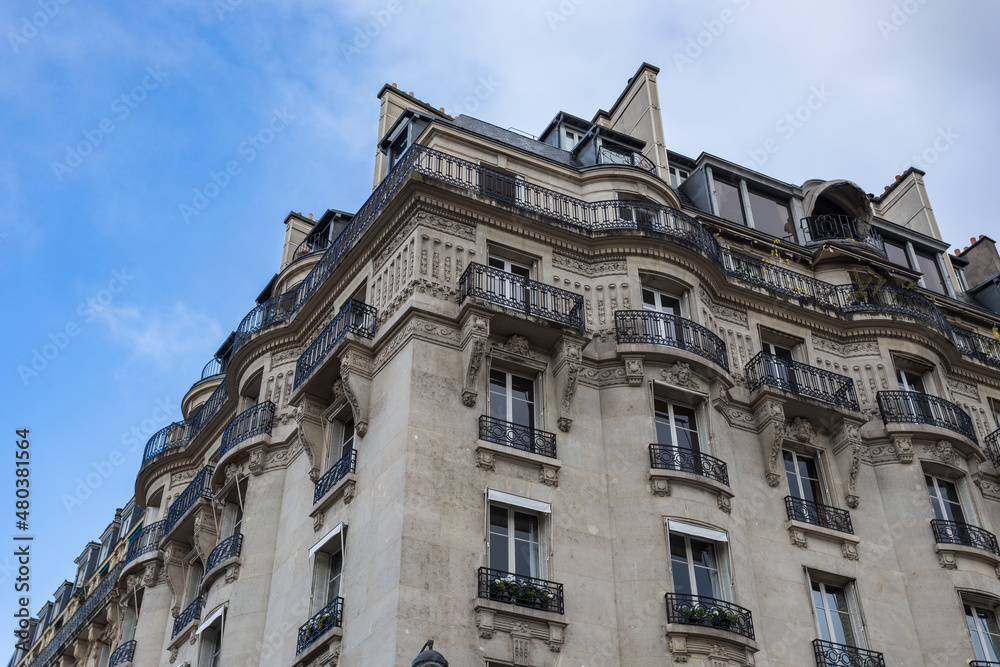 Looking up at vintage Parisian apartment building with iron balconies