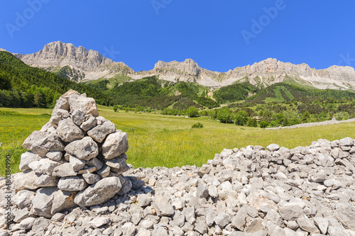 Rocaille avec cairn, falaise et ligne de crête de plateaux calcaires. Balcon Est du Vercors, réserve naturelle des Hauts Plateaux, Grand Veymont. © YVO-Photos