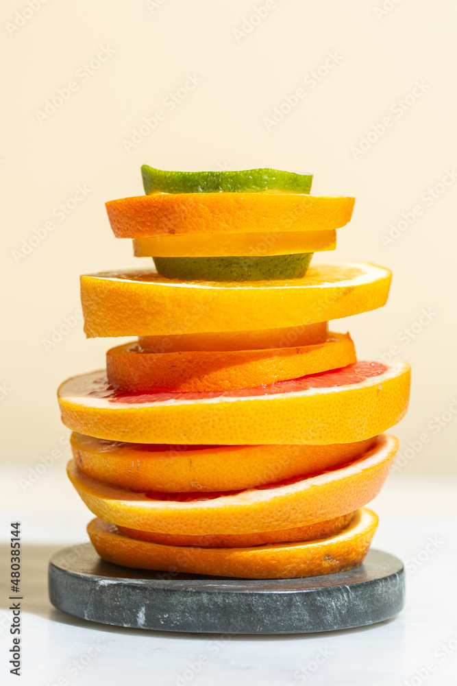 Slices of citrus fruits are stacked on a stone stand, fruit cocktail, fresh juice Slices of citrus fruits are stacked on a stone stand, fruit cocktail, fresh juice