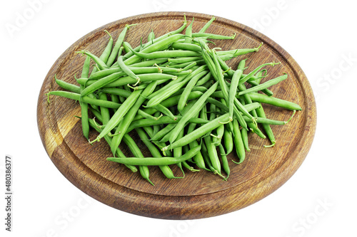 Green beans on a round cutting board isolated in white background. Healthy food. File contains clipping path.