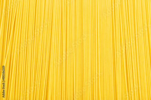 Raw pasta spaghetti background. Natural traditional Italian food. Yellow italian pasta.