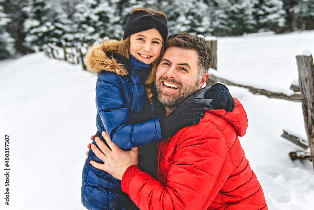 Handsome dad and his daughter are having fun outdoor in winter