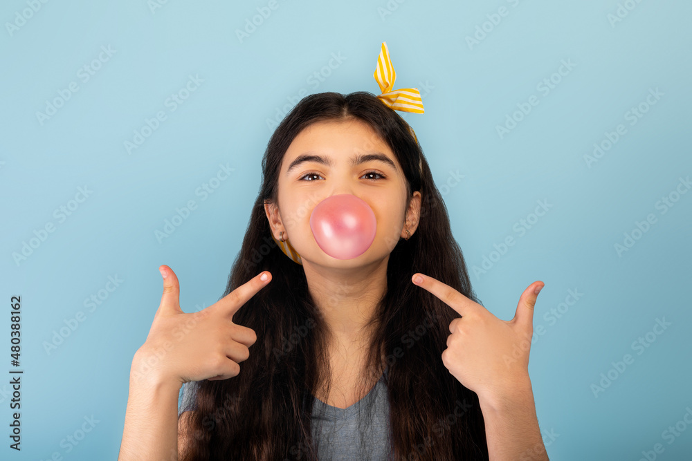 Funny Indian teen girl blowing bubble from sugar free chewing gum