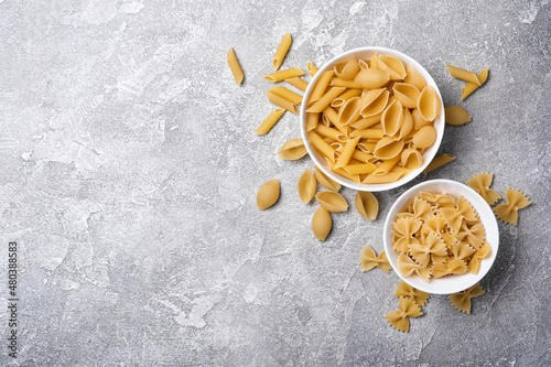 Mix of Italian raw pasta in white bowls photo