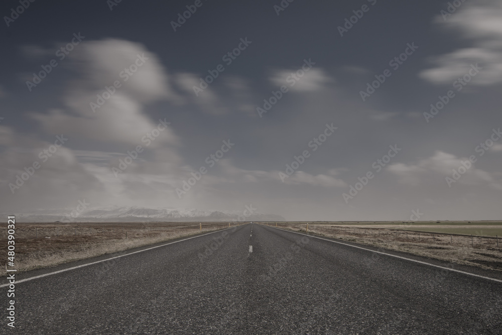 Einsame Straße in Island mit bewölktem Himmel
