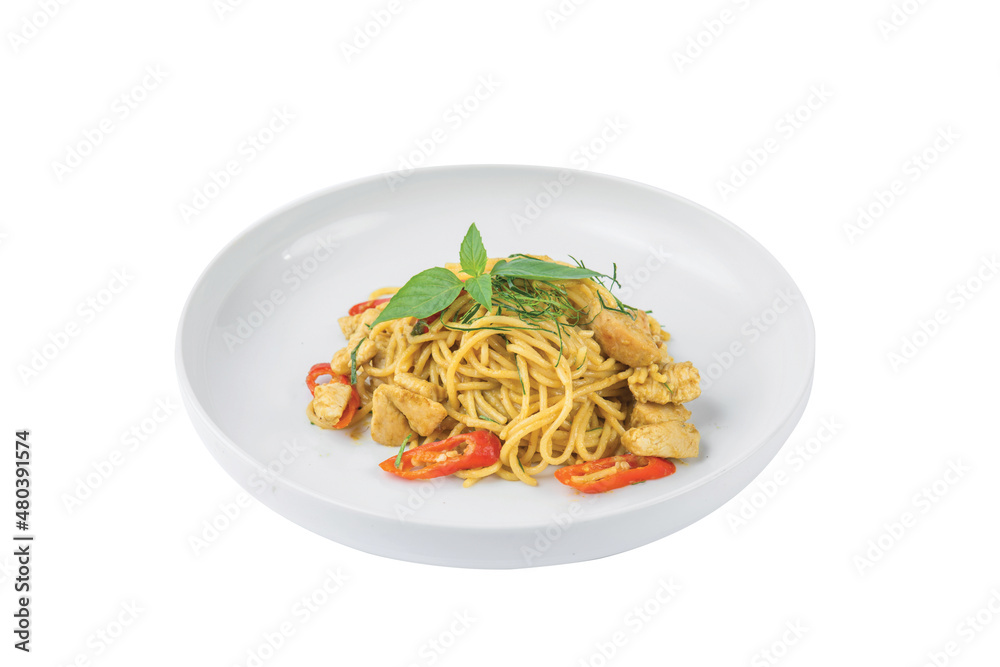 Green curry spaghetti with chicken in a white plate placed Green curry spaghetti with chicken in a white plate placed
