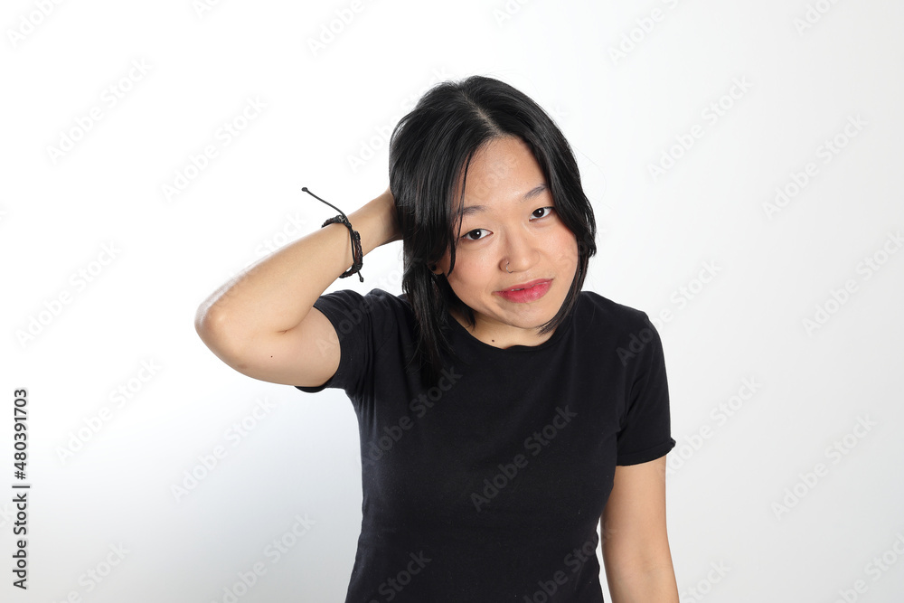 Young attractive south east asian woman pose face expression emotion on white background think wander scratch head ear Young attractive south east asian woman pose face expression emotion on white background think wander scratch head ear