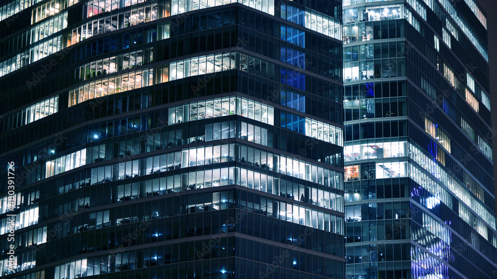 Amazing night cityscape. Office building at night, building facade with glass and lights. View with illuminated modern skyscraper. Scenic glowing windows of skyscrapers at evening. Amazing night cityscape. Office building at night, building facade with glass and lights. View with illuminated modern skyscraper. Scenic glowing windows of skyscrapers at evening.