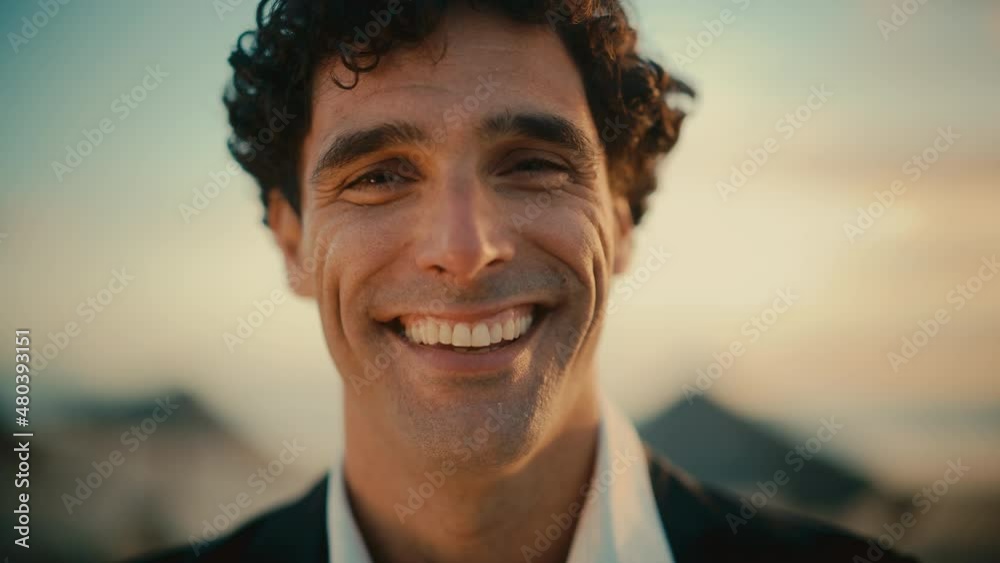 Close Up Portrait of a Happy Young Adult Male with Curly Hair and Brown Eyes Posing for Camera. Handsome Multiethnic Caucasian Male in a Suit Charmingly Smiling. Warm Color Edit. Close Up Portrait of a Happy Young Adult Male with Curly Hair and Brown Eyes Posing for Camera. Handsome Multiethnic Caucasian Male in a Suit Charmingly Smiling. Warm Color Edit.