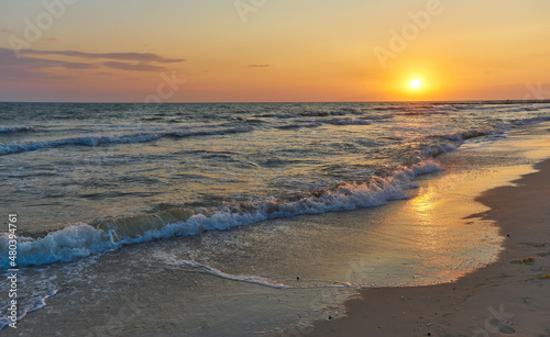 Soft sea waves and bubbles on the beach with sunset sky