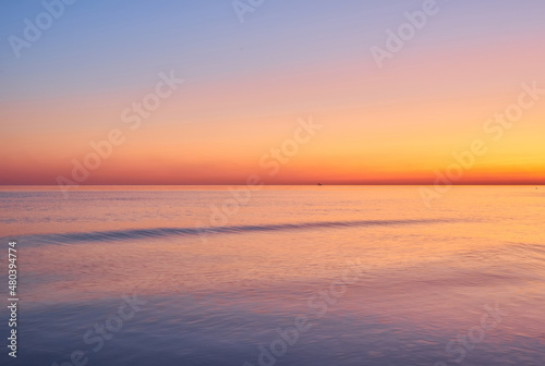 Vivid sunset sky and motion blur of the sea under with long exposure effect. © Ryzhkov Oleksandr