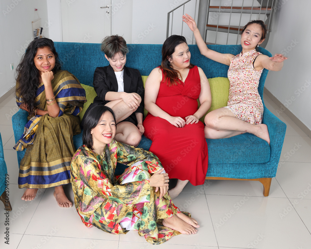 Young Asian woman group talk gossip chat sing making funny mocking faces expression on blue living room sofa sit on floor Young Asian woman group talk gossip chat sing making funny mocking faces expression on blue living room sofa sit on floor