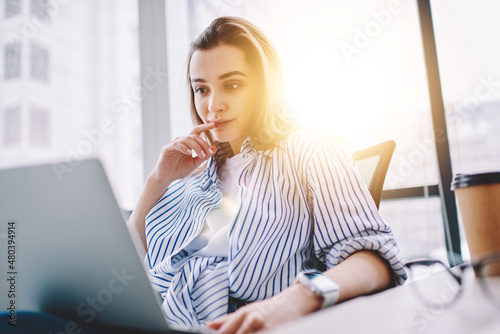 Caucasian female IT professional interested on received freelance task with program code, smart casual graphic designer working remotely on ideas for web project installing app for editing media photo