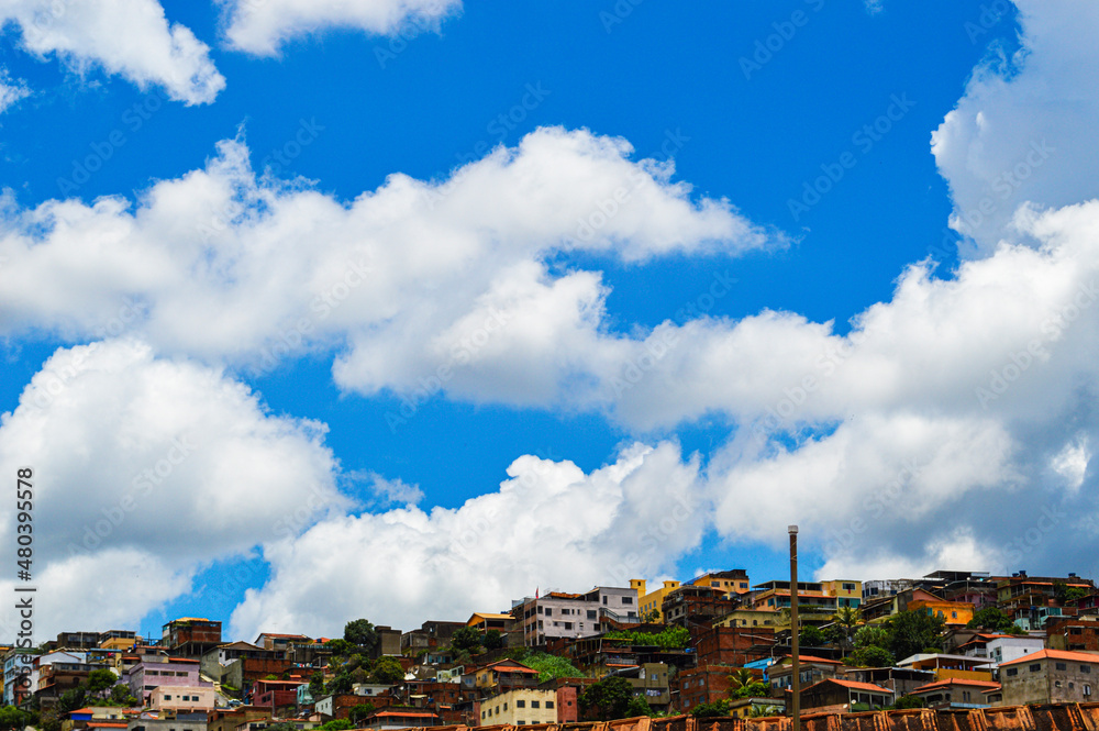 Fototapeta premium Beautiful landscape with blue sky many clouds and houses at the top of the hill. Sky Blue Clouds Houses on the hill.