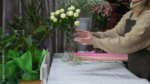 Female florist giving a beautiful bouquet to the male customer in flower shop. Small business, commerce concept. Work day in floral business